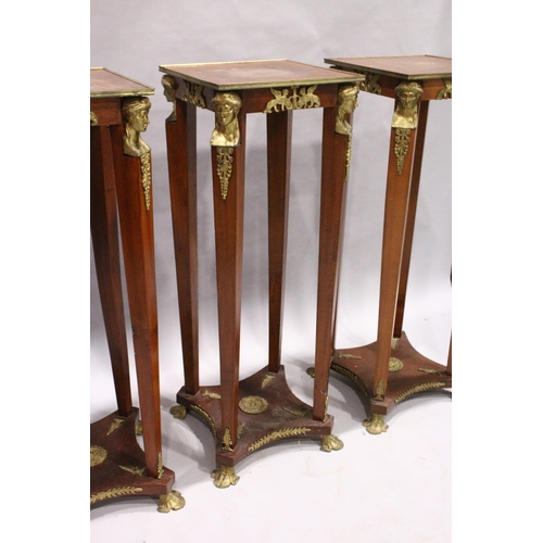 75 - A SET OF THREE SQUARE TOP TORCHERES  with mask mounts, tapering supports, undertier and gilt legs.  ... 