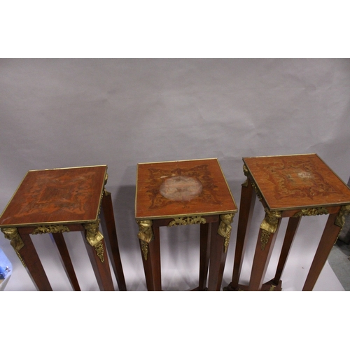 75 - A SET OF THREE SQUARE TOP TORCHERES  with mask mounts, tapering supports, undertier and gilt legs.  ... 