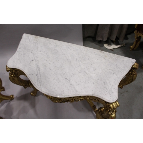 85 - A PAIR OF GILDED AND MARBLE TOP CONSOLE TABLES with white speckled marble tops, gilt bases with curv... 