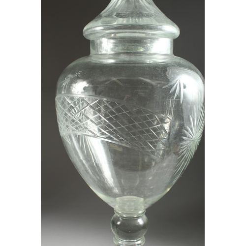 97 - A LARGE PAIR OF CUT GLASS URN, SHAPED VASES AND COVERS, 31 ins. high.