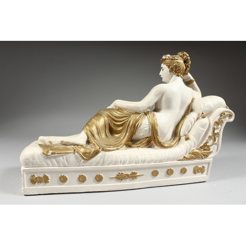 99 - A POTTERY SEMI NUDE on a chaise longue, 15 ins. long