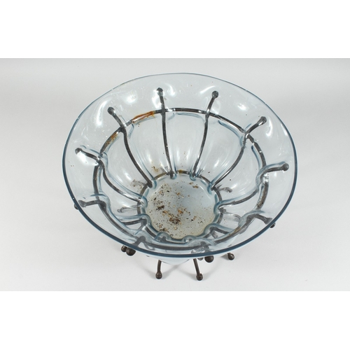 114 - A TINTED SHAPED GLASS BOWL on a wrought iron stand, 13 ins diameter.