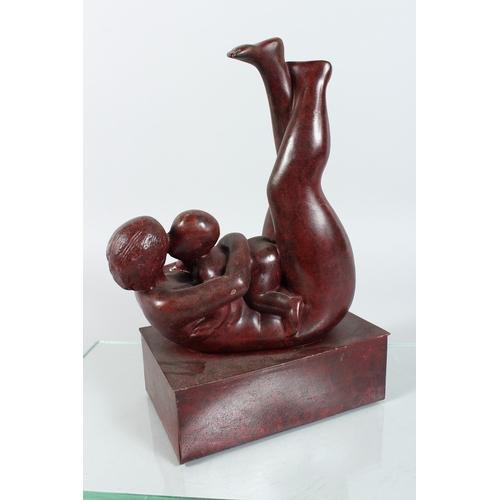 137 - A MODERN BRONZE MOTHER AND CHILD on a rectangular base. 12 ins high.