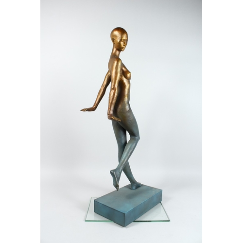 144 - AN ABSRACT STANADING BRONZE NUDE on a rectangular base. 16 ins high.