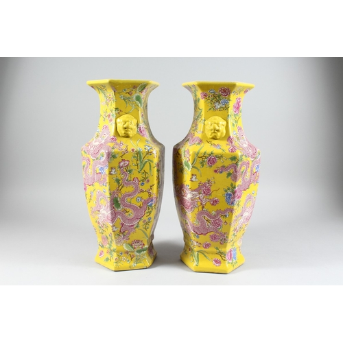 149 - A PAIR OF YELLOW DRAGON DESIGN OCTAGONAL VASES 17 ins high.