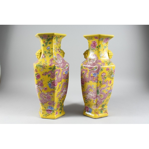 149 - A PAIR OF YELLOW DRAGON DESIGN OCTAGONAL VASES 17 ins high.