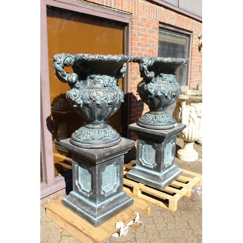 186 - A LARGE PAIR OF BLACK STONE MARBLE ELVES TWO HANDLED URNS ON STANDS 4 ft 10 ins high