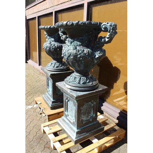 186 - A LARGE PAIR OF BLACK STONE MARBLE ELVES TWO HANDLED URNS ON STANDS 4 ft 10 ins high