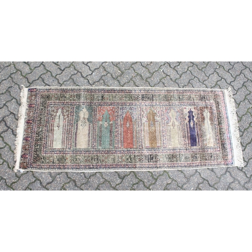 221 - AN UNUSUAL PERSIAN PRAYER RUG, the central panel with eight arches and hanging lamps, within a geome... 