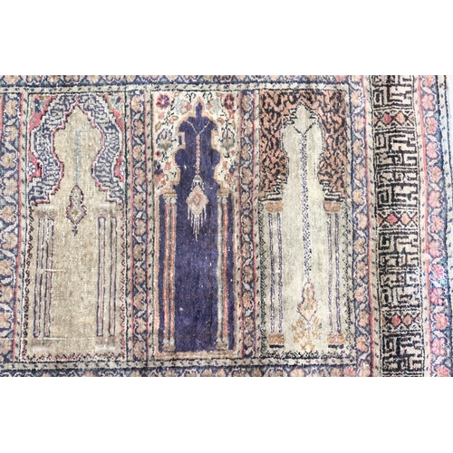 221 - AN UNUSUAL PERSIAN PRAYER RUG, the central panel with eight arches and hanging lamps, within a geome... 