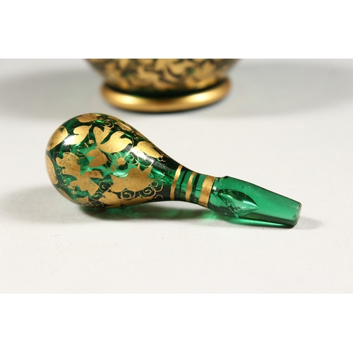 239 - A BOHEMIAN GREEN AND GILT SCENT BOTTLE AND STOPPER. 7 ins high.