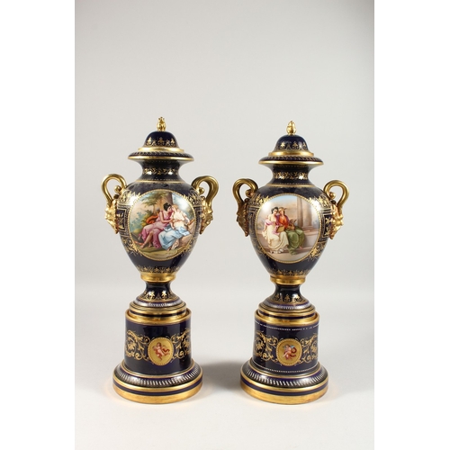 276 - A SUPERB PAIR OF VIENNA VASES, COVERS AND STANDS, the rich blue ground edged in gilt and painted wit... 