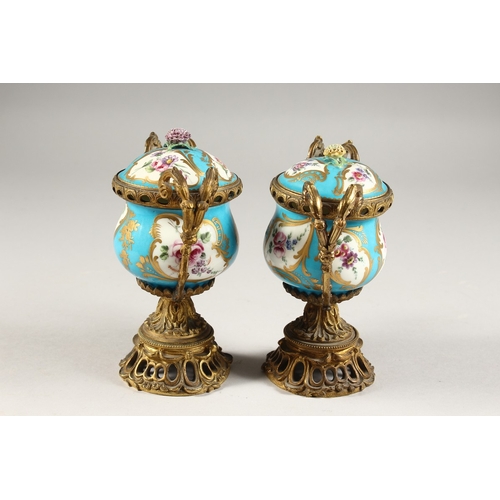 281 - A GOOD PAIR OF 19TH CENTURY SEVRES PORCELAIN AND ORMOLU TWO-HANDLED VASES AND COVERS, blue ground en... 