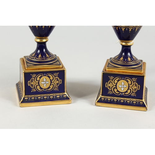 294 - A SUPERB PAIR OF VIENNA TWO HANDLED VASES AND COVERS, rich blue and gilt grounds, painted with a ban... 