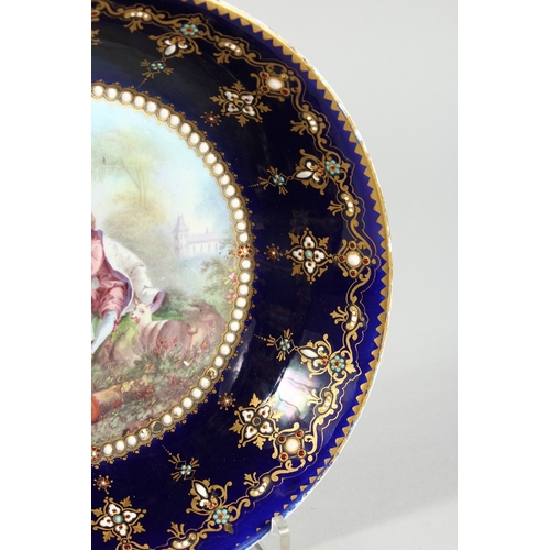 299 - AN 18TH CENTURY SEVRES PORCELAIN CIRCULAR DEEP DISH rich blue ground, pearl work, the  centre painte... 