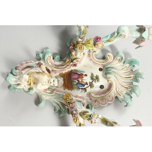 308 - A GOOD PAIR OF MEISSEN PORCELAIN TWO LIGHT WALL SCONCES with cupid and encrusted with flowers and pa... 