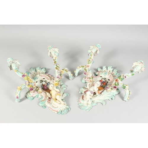 308 - A GOOD PAIR OF MEISSEN PORCELAIN TWO LIGHT WALL SCONCES with cupid and encrusted with flowers and pa... 