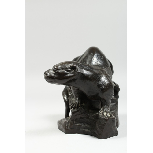 341 - A BRONZED FIGURE OF A OTTER on a rocky base,signed T Wick.