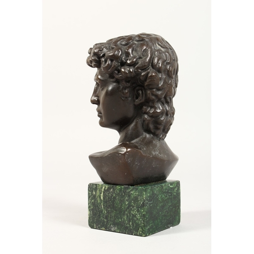 359 - AFTER THE ANTIQUE, A bronze bust on a marble plinth. 6 ins high