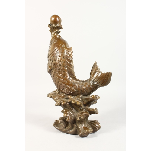 364 - A CHINESE BRONZE CARP on a scrolling base. 7 ins high.