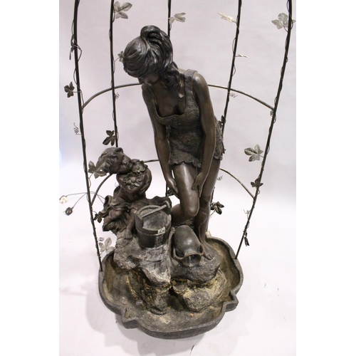 1043 - A FINE BRONZED WATER FEATURE, a classical female and Cupid standing on a metal base and arbour.