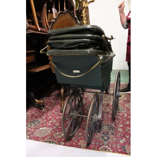 1051 - A RARE VICTORIAN METAL, WOOD AND LEATHER PRAM with folding hood, porcelain handles, wooden wheels. 3... 