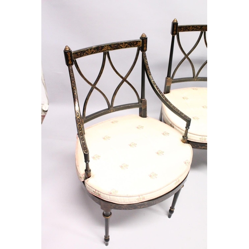 1055 - A SET OF FOUR BLACK AND GILT CHAIRS, two with arms, with cross fret backs and cane seats.