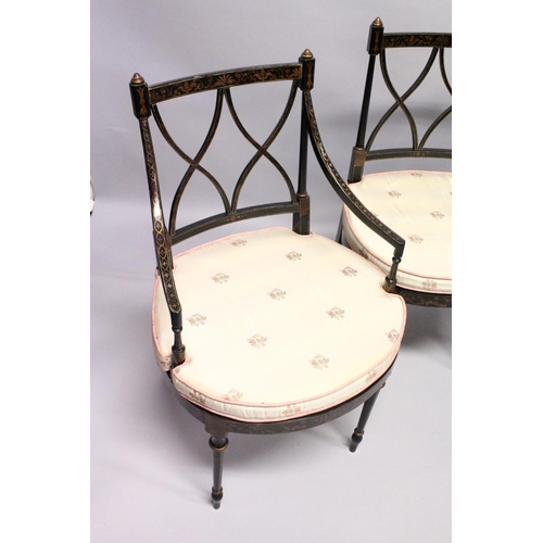 1055 - A SET OF FOUR BLACK AND GILT CHAIRS, two with arms, with cross fret backs and cane seats.