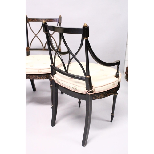 1055 - A SET OF FOUR BLACK AND GILT CHAIRS, two with arms, with cross fret backs and cane seats.