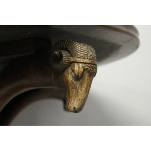 1056 - A REGENCY MAHOGANY CIRCULAR TABLE, with inset leather top with four curving rams masks on hoof feet.... 
