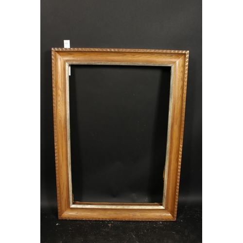1050 - A carved oak frame with silvered inner ornaments, rebate size 24  x 36 , 61cm x 92cm.