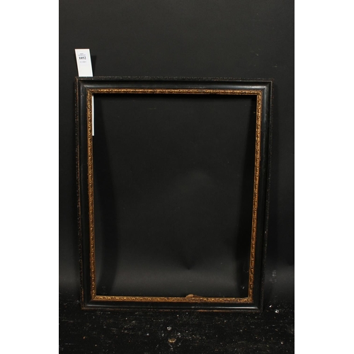 1052 - An 18th century carved and ebonised frame with a gilded inner ornament, rebate size 16  x 20.25