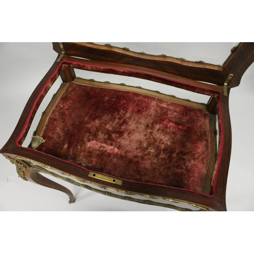 16 - A GOOD 19TH CENTURY FRENCH ROSEWOOD BIJOUTERIE TABLE with ornate mounts, lift-up glazed top, glass s... 