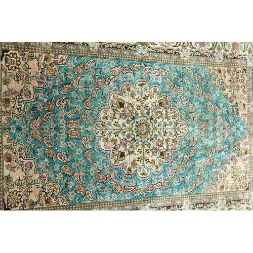 1003 - A SMALL PERSIAN SILK RUG, pale blue ground with fine floral design. 4ft x 2ft 6ins.