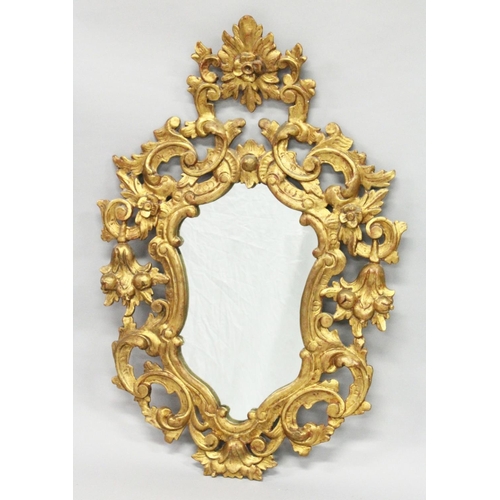 1027 - AN 18TH / 19TH CENTURY ITALIAN FLORENTINE GILT WOOD MIRROR of shield shape, with pierced and carved ... 