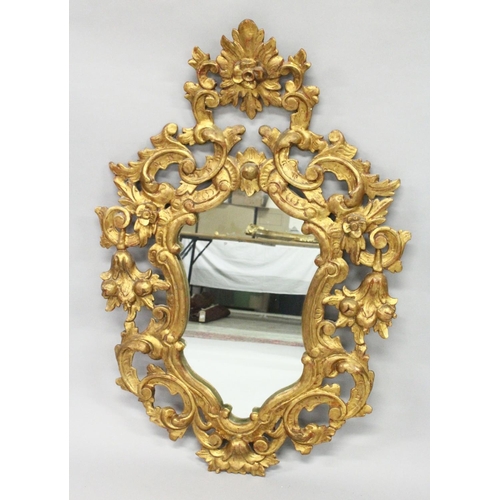 1027 - AN 18TH / 19TH CENTURY ITALIAN FLORENTINE GILT WOOD MIRROR of shield shape, with pierced and carved ... 