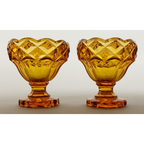 1079 - A PAIR OF BOHEMIAN AMBER GLASS PEDESTAL SALTS.