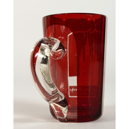 1081 - A BOHEMIAN RUBY GLASS TANKARD engraved with a church. 4.5ins high.