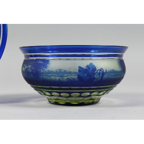 1084 - A BOHEMIAN BLUE TINTED BOWL AND STAND with a landscaped decoration.