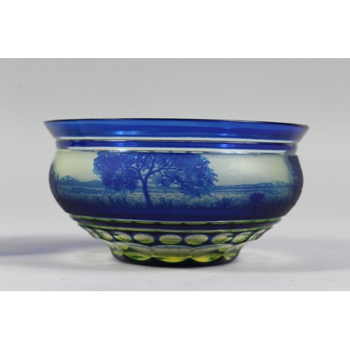 1084 - A BOHEMIAN BLUE TINTED BOWL AND STAND with a landscaped decoration.