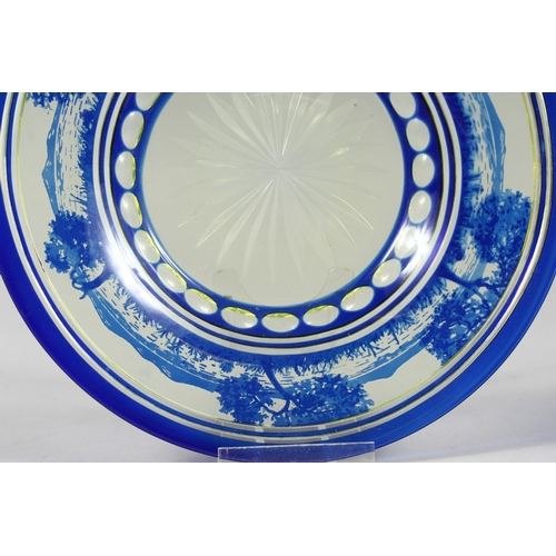 1084 - A BOHEMIAN BLUE TINTED BOWL AND STAND with a landscaped decoration.