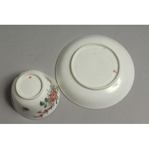 1096 - AN 18TH CENTURY CHELSEA RED ANCHOR MARKED TEA BOWL AND SAUCER painted with Meissen style flowers.