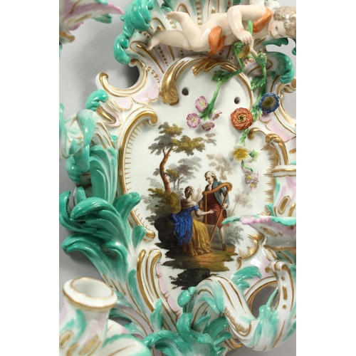 1147 - A PAIR OF THREE-BRANCH PORCELAIN WALL LIGHTS IN THE MEISSEN STYLE, decorated with cherubs, flowers, ... 