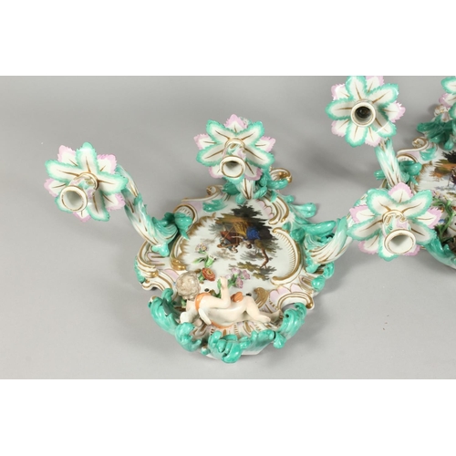 1147 - A PAIR OF THREE-BRANCH PORCELAIN WALL LIGHTS IN THE MEISSEN STYLE, decorated with cherubs, flowers, ... 