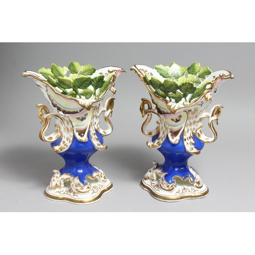 1179 - A PAIR OF COALPORT VASES with blue ground, moulded with leaves and painted with butterflies.