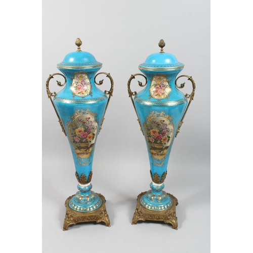 1206 - A PAIR OF SEVRES STYLE PORCELAIN AND ORMOLU TWIN HANDLED VASES AND COVERS decorated with flowers, 27... 