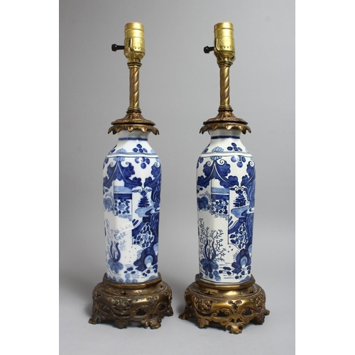 1238 - A PAIR OF CHINESE BLUE AND WHITE PORCELAIN LAMPS with ormolu mounts. 19ins high.