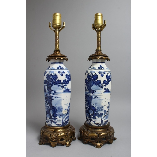 1238 - A PAIR OF CHINESE BLUE AND WHITE PORCELAIN LAMPS with ormolu mounts. 19ins high.