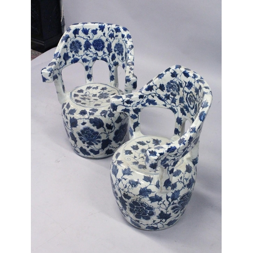 1244 - A PAIR OF CHINESE BLUE AND WHITE POTTERY GARDEN ARMCHAIRS. 26ins high.