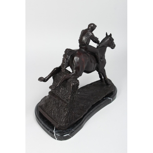 1266 - A GOOD BRONZE OF A HORSE AND JOCKEY JUMPING OVER A HEDGE. 14ins long.